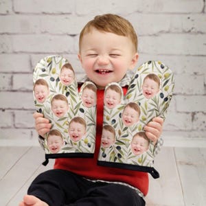 May include: A white ceramic mug with a black handle and the text "But First, Coffee" in a bold, black font. The mug is set against a blurred background, suggesting a cozy setting.