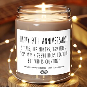 May include: A brown candle with a white label that reads "Happy 9th Anniversary! 9 years, 108 months, 469 weeks, 3285 days & 78840 hours together but who is counting? Natural soy wax blend - 100% cotton wick".