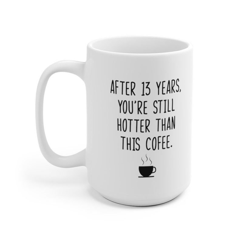 May include: White ceramic coffee mug with black text that reads "After 13 years. You're still hotter than this coffee."  A small black and white illustration of a steaming cup of coffee is below the text.