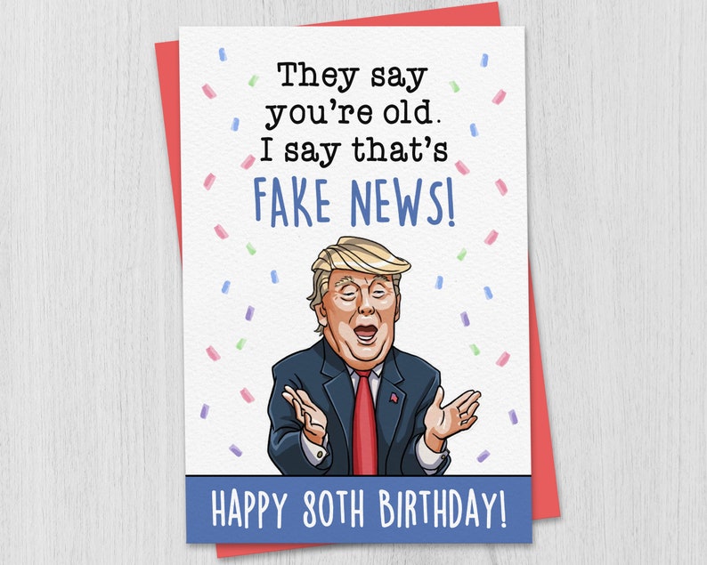 May include: A humorous birthday card featuring a cartoon illustration of Donald Trump with confetti and the text "They say you're old. I say that's FAKE NEWS! Happy 80th Birthday!"