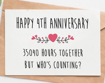 May include: A white card with black text that reads "Happy 4th Anniversary" with a pink heart and floral design. The text below reads "35040 hours together but who's counting?"