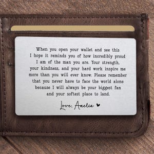 May include: A brown leather wallet with a silver card insert. The card has an engraved message that reads, "When you open your wallet and see this...Love, Amelia."