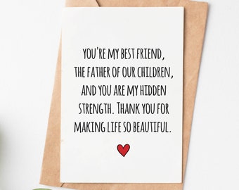 May include: A white card with a handwritten message that reads "You're my best friend, the father of our children, and you are my hidden strength. Thank you for making life so beautiful." A small red heart is drawn at the bottom of the card.