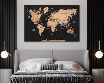 May include: A black and gold world map with push pins, hanging above a gray upholstered bed with black bedding and white pillows. The map is on a corkboard and has the names of countries and oceans labeled in gold.