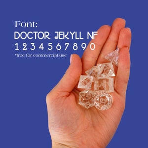 May include: A hand holding a set of clear, multi-sided dice with numbers etched on each face. The dice are in a variety of shapes and sizes. The font used for the numbers is called "Doctor Jekyll NF".  *free for commercial use