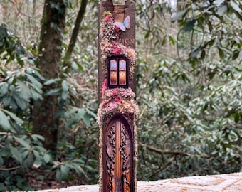 May include: A decorative book featuring a carved wooden door design, embellished with flowers, greenery, and a butterfly. The word "ION" is visible on the spine. The book is set against a blurred forest backdrop.