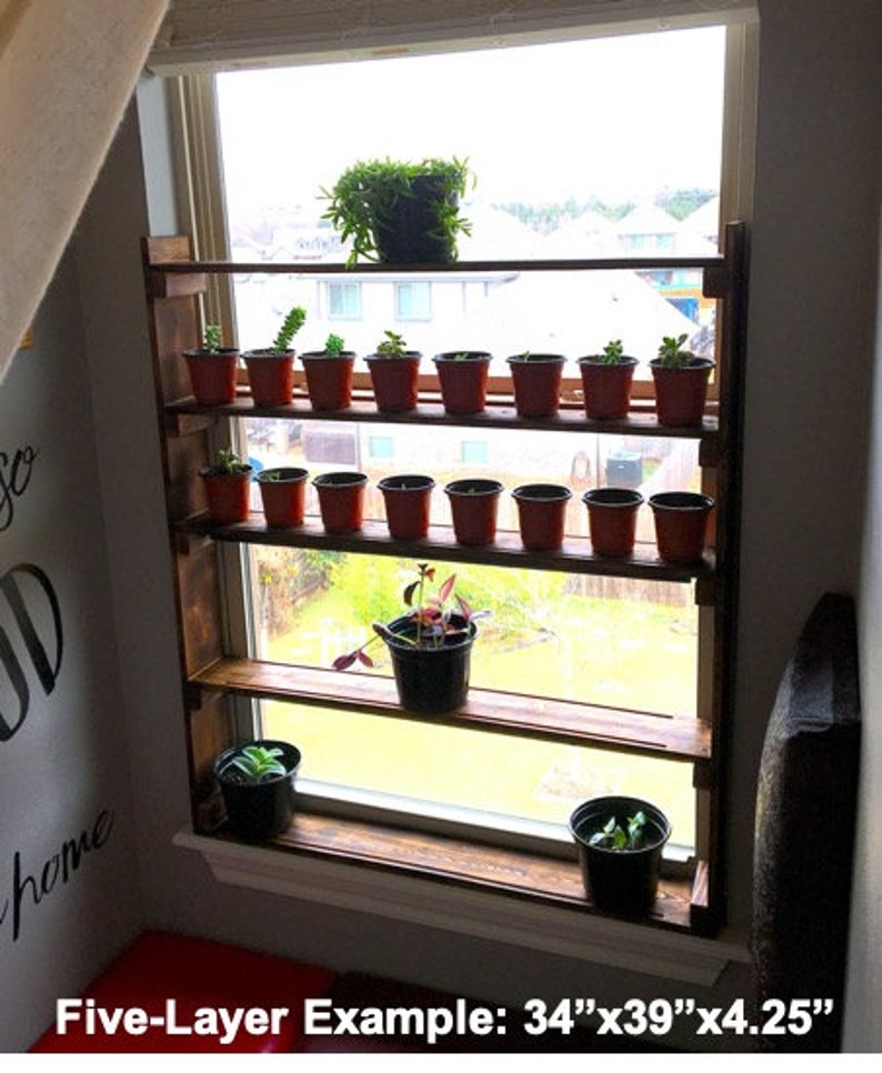 May include: Five-layer wooden shelf unit with plants in pots, mounted on a window frame. The shelf is 34 inches wide by 39 inches tall and 4.25 inches deep.