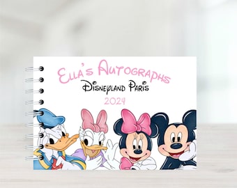 Puede incluir: Un libro de autógrafos blanco con encuadernación en espiral. La portada presenta el texto "Ella's Autographs Disneyland Paris 2024" en letras rosas. Los personajes Mickey Mouse, Minnie Mouse, Donald Duck y Daisy Duck aparecen en la portada.