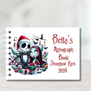 Könnte beinhalten: Ein weißes Spiral-Autogrammbuch mit einer bunten Illustration von Jack Skellington und Sally aus Nightmare Before Christmas. Der Text auf dem Cover lautet "Bella's Autograph Book Disneyland Paris 2024".