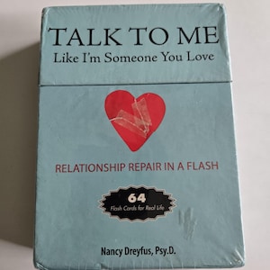 May include: A light blue box of flashcards titled "TALK TO ME Like I'm Someone You Love." The box features a red heart with tape and the text "RELATIONSHIP REPAIR IN A FLASH." It contains 64 flash cards for real life, by Nancy Dreyfus, Psy.D.