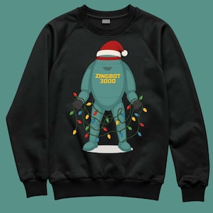 May include: Black sweatshirt featuring a cartoon robot named "ZINGBOT 3000" wearing a Santa hat and wrapped in colorful Christmas lights. The robot is teal with yellow text.