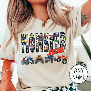 woman model is wearing a natural bella canvas t-shirt that is customized to say "MOMSTER Jam" with a row of 4 multi-colored monster trucks. The letters of Momster are with a Monster trucks pattern inside each letter. Very fun colorful Mama Mom T-shirt perfect for Monster truck shows or Birthday Party Mom Shirt, Boy Mama Ne Mom Toddler Mom shirt with matching family shirts available- dadster, kidster or custom name shirts as family outfit.