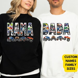 Op de afbeelding: Zwart-wit sweatshirt met het woord "MAMA" in grote letters, met een patroon van monstertrucks in de letters. Wit sweatshirt met het woord "DADA" in grote letters, met een patroon van monstertrucks in de letters. De tekst onder de afbeelding luidt "Aangepaste namen Gezinsmaten".