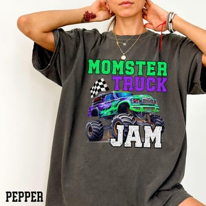 Model is wearing a comfy soft comfort colors T-Shirt Tee Green Purple Monster truck big Tires Black white Checkered flag family Matching Jam Birthday Boy dude Dadster Kidster