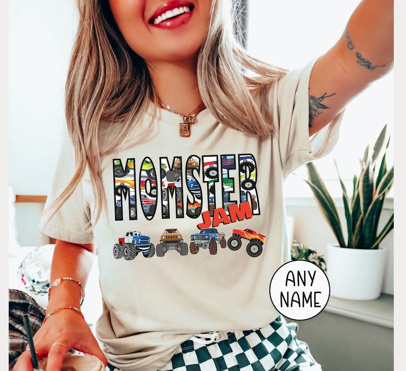 woman model is wearing a natural bella canvas t-shirt that is customized to say "MOMSTER Jam" with a row of 4 multi-colored monster trucks. The letters of Momster are with a Monster trucks pattern inside each letter. Very fun colorful Mama Mom T-shirt perfect for Monster truck shows or Birthday Party Mom Shirt, Boy Mama Ne Mom Toddler Mom shirt with matching family shirts available- dadster, kidster or custom name shirts as family outfit.