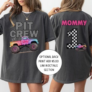 Pode incluir: T-shirt cinza escuro com um gr&aacute;fico de monster truck colorido e o texto "PIT CREW" na frente. A parte de tr&aacute;s da camisa apresenta a palavra "MOMMY" e o n&uacute;mero "1" com um gr&aacute;fico de monster truck.