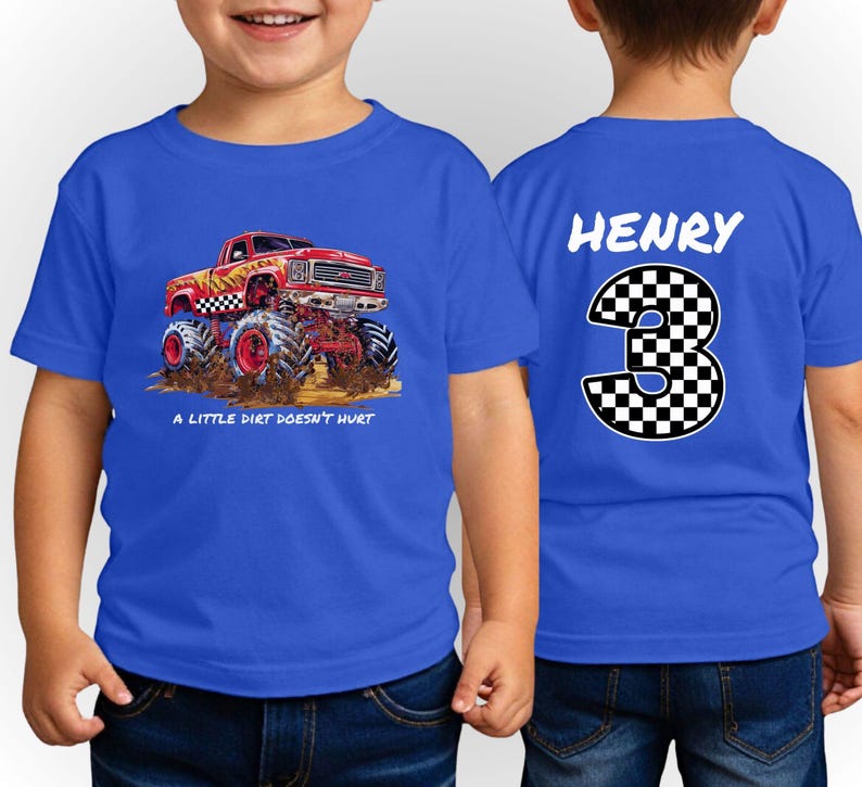 Peut inclure: T-shirt bleu &agrave; manches courtes avec un motif de monster truck rouge, des d&eacute;tails &agrave; carreaux noirs et blancs et le texte "A LITTLE DIRT DOESN'T HURT." Le dos affiche le nom "HENRY" au-dessus d'un grand chiffre "3" &agrave; motif &agrave; carreaux.