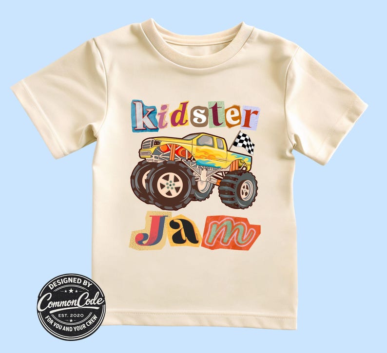 Puede incluir: Camiseta color crema con un gr&aacute;fico de cami&oacute;n monstruo colorido y las palabras "Kidster Jam". El dise&ntilde;o incluye un cami&oacute;n amarillo, neum&aacute;ticos negros grandes y una bandera a cuadros. La camiseta tambi&eacute;n tiene el texto "Designed by Common Code, Est. 2020."