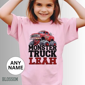 May include: Pink t-shirt with a monster truck graphic and the text "Monster Truck Leah".