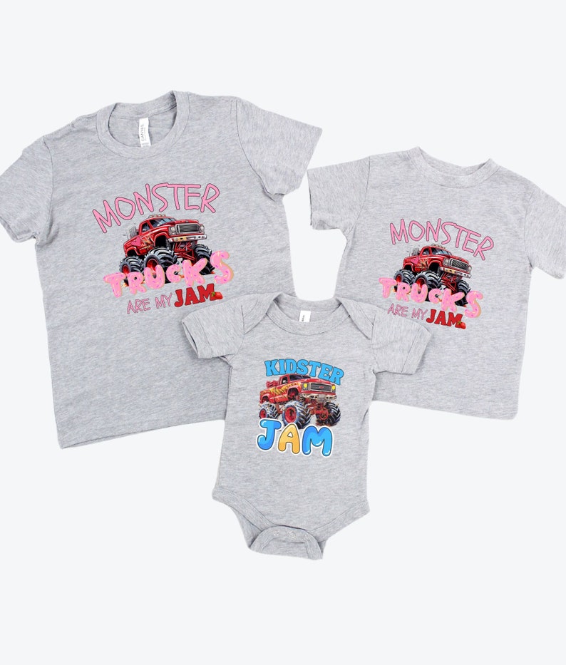 May include: Three gray t-shirts and a onesie with monster truck graphics. The shirts have the text "MONSTER TRUCKS ARE MY JAM" in pink. The onesie says "KIDSTER JAM" with a monster truck illustration.