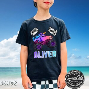 May include: Black t-shirt featuring a colorful graphic of a unicorn monster truck with the name "OLIVER" in a gradient font. The design includes checkered flags and the text "DESIGNED BY COMMON CODE EST. 2020 FOR YOU AND YOUR CREW."