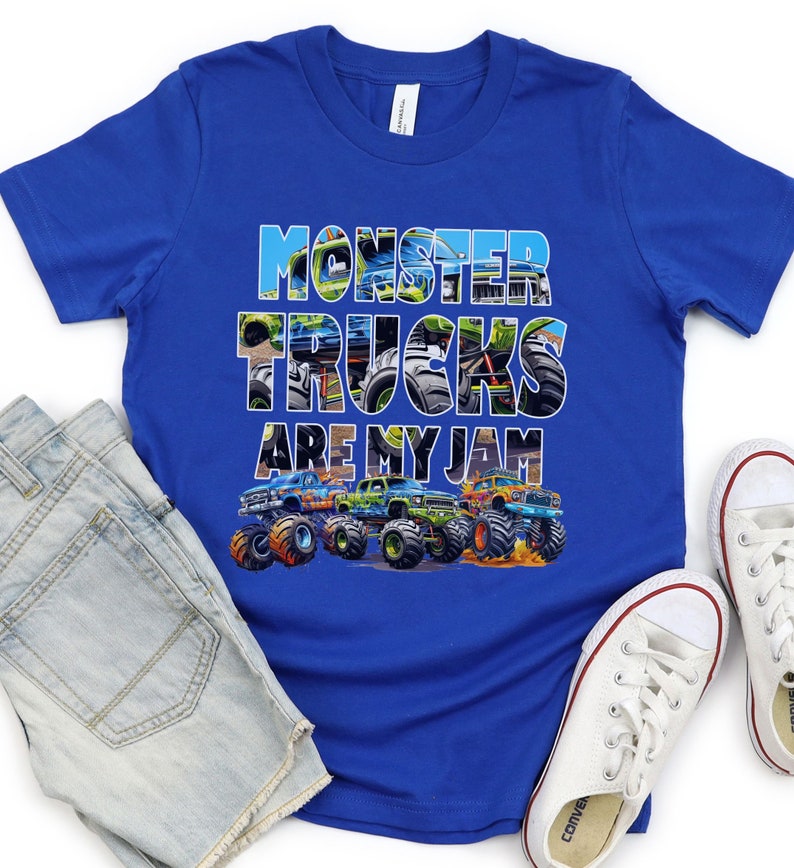 May include: A royal blue t-shirt with a graphic of monster trucks. The text "Monster Trucks Are My Jam" is printed on the shirt. The graphic is made up of images of monster trucks.