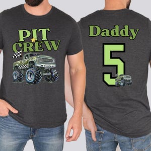 Daddy wearing a dark gray t-shirt with the front of the shirt says "PIT CREW" above a monster truck design. The back of the shirt says "Daddy 5" with a monster truck graphic.