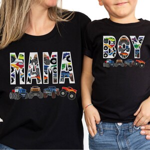 May include: Black t-shirts with matching designs. One shirt says "MAMA" and the other says "BOY", both filled with monster truck graphics. Below each word are illustrations of monster trucks in various colors.