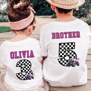 Pode incluir: Duas camisetas brancas com designs correspondentes. Uma camisa diz "OLIVIA" com um n&uacute;mero 3 quadriculado e um gr&aacute;fico de monster truck. A outra diz "BROTHER" com um n&uacute;mero 5 quadriculado e um gr&aacute;fico de monster truck.
