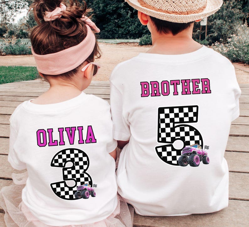 Pode incluir: Duas camisetas brancas com designs correspondentes. Uma camisa diz "OLIVIA" com um n&uacute;mero 3 quadriculado e um gr&aacute;fico de monster truck. A outra diz "BROTHER" com um n&uacute;mero 5 quadriculado e um gr&aacute;fico de monster truck.