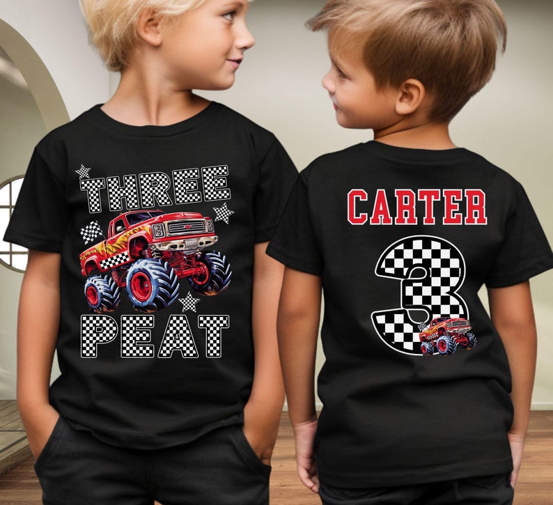 Op de afbeelding: Zwarte t-shirts met een monster truck ontwerp. De voorkant van het shirt zegt "THREE PEAT" met een rode monster truck afbeelding. De achterkant van het shirt zegt "CARTER" en een nummer "3" met een monster truck afbeelding.