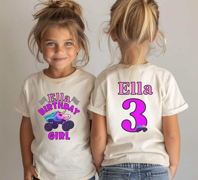 Pictured is a young girl wearing a beige natural colored t-shirt 2-sided design which says Ella Birthday Girl in pink and purple letters with a unicorn sparkle smash monster truck and 2 checkered flags. on the back there is custom name Ella a big number 3 and a small version of the truck graphic