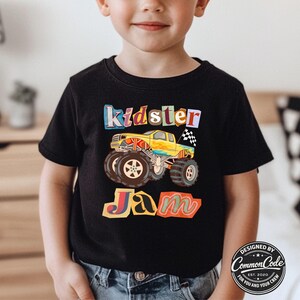 Puede incluir: Camiseta negra con un gr&aacute;fico de monster truck colorido y las palabras "Kidster Jam". El dise&ntilde;o incluye un cami&oacute;n amarillo con neum&aacute;ticos grandes y una bandera a cuadros. Dise&ntilde;ado por Common Code.