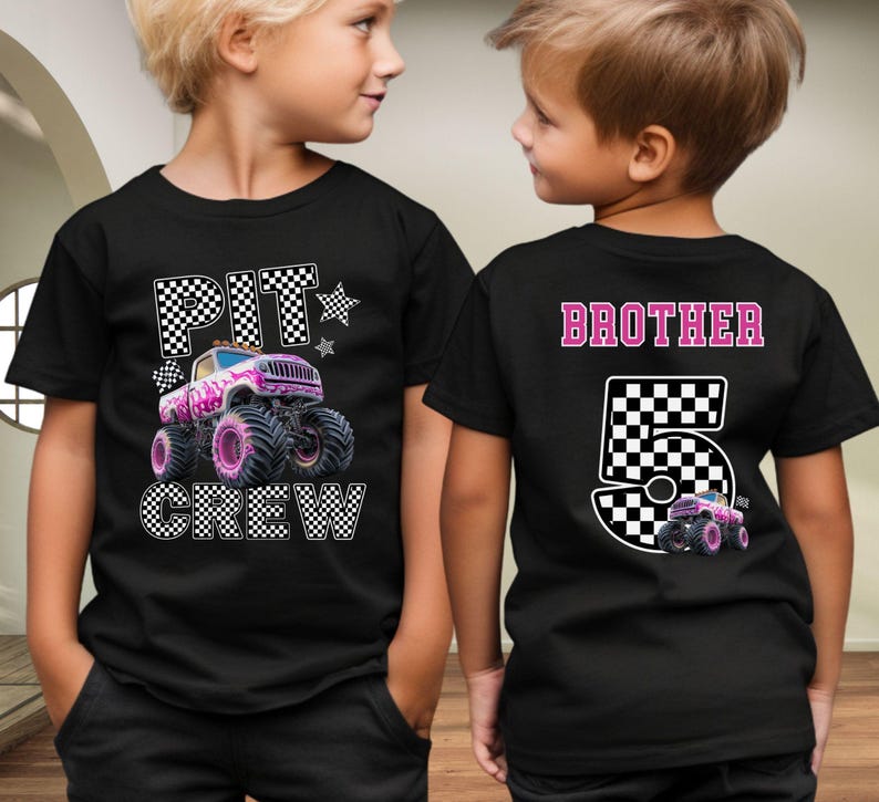 Pode incluir: T-shirts pretas com um design de monster truck. Uma camisa apresenta "PIT CREW" e um gr&aacute;fico de monster truck rosa e branco. A outra camisa diz "BROTHER 5" com um gr&aacute;fico de caminh&atilde;o correspondente. Ambas as camisas t&ecirc;m um design de bandeira quadriculada.