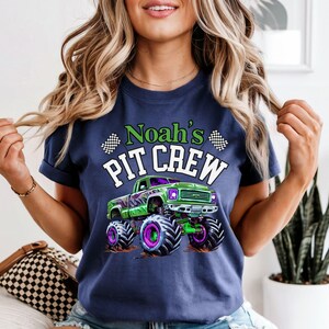 Woman is wearing a navy blue comfort colors T-shirt which says Noah's PIT CREW in green and white letters with a big green and purple monster truck graphic and 2 checkered flags