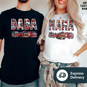 May include: Two t-shirts with a fire truck design. The black t-shirt says "DADA" and the white t-shirt says "MAMA".