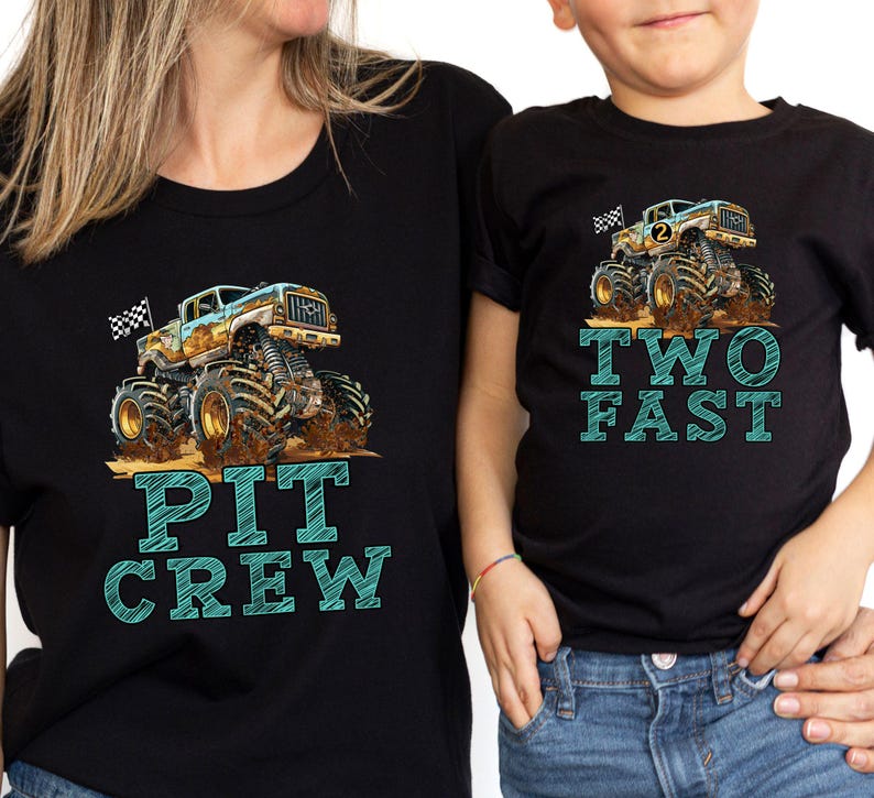 Pictured is a woman and child wearing black T-Shirts with big monster truck and checkered flags. Mom's shirt says PIT CREW in large graphic letters and boy's shirt says TWO FAST in same font