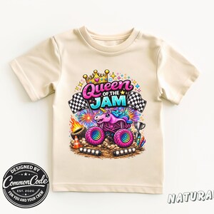 Peut inclure: Un t-shirt de couleur naturelle avec un graphisme color&eacute; d'un monster truck avec un design de licorne et le texte "Queen of the Jam". Le design comprend des drapeaux &agrave; damier, une couronne et un troph&eacute;e. Le t-shirt porte &eacute;galement le texte "Designed by Common Code" et "Natural".