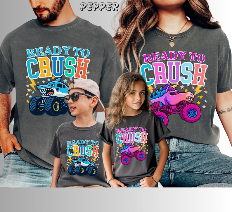 Ready to Crush Monster Truck Shirt | Comfort Colors Kids & Adult Tee | Colorful Monster Truck Shirt | Family Matching Shirts. Family of 4 has matching Monster Truck Jam themed t-shirts in Comfort Colors Brand in Pepper. The Man and Boy's say "Ready to Crush" in varsity style multi-colored letters. with a blue megalodon shark monster truck with stars and lightning. The Mom and girl's shirts say "READY to CRUSH" with a Sparkle unicorn Pink Smash Monster Truck with stars and lightning.