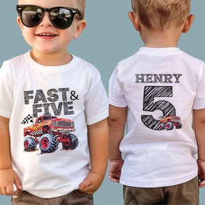 May include: White t-shirt with a red monster truck graphic and the text "FAST & FIVE". The back of the shirt has the name "HENRY" above a large number "5" and a smaller monster truck graphic.