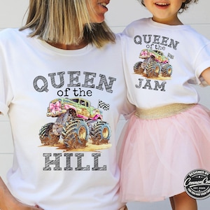 Pictured is a Mom and Daughter wearing white t-shirts. Mom's says Queen of the Hill with pink and green monster truck and checkered flag. Daughter is wearing matching tee but hers says Queen of the Jam. Customized to your liking.