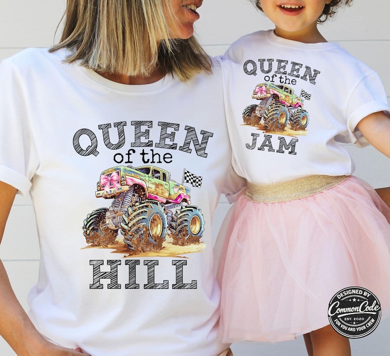 Pictured is a Mom and Daughter wearing white t-shirts. Mom's says Queen of the Hill with pink and green monster truck and checkered flag. Daughter is wearing matching tee but hers says Queen of the Jam. Customized to your liking.