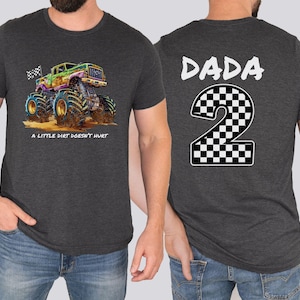 May include: Charcoal grey t-shirt with a vibrant monster truck illustration and the phrase "A LITTLE DIRT DOESN'T HURT." The back of the shirt has the word "DADA" above a checkered number "2."
