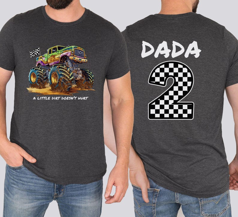 May include: Charcoal grey t-shirt with a vibrant monster truck illustration and the phrase "A LITTLE DIRT DOESN'T HURT." The back of the shirt has the word "DADA" above a checkered number "2."