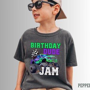 K&ouml;nnte beinhalten: Ein dunkelgraues T-Shirt mit einem gr&uuml;nen Monstertruck-Motiv und dem Text "Birthday Dude Jam".