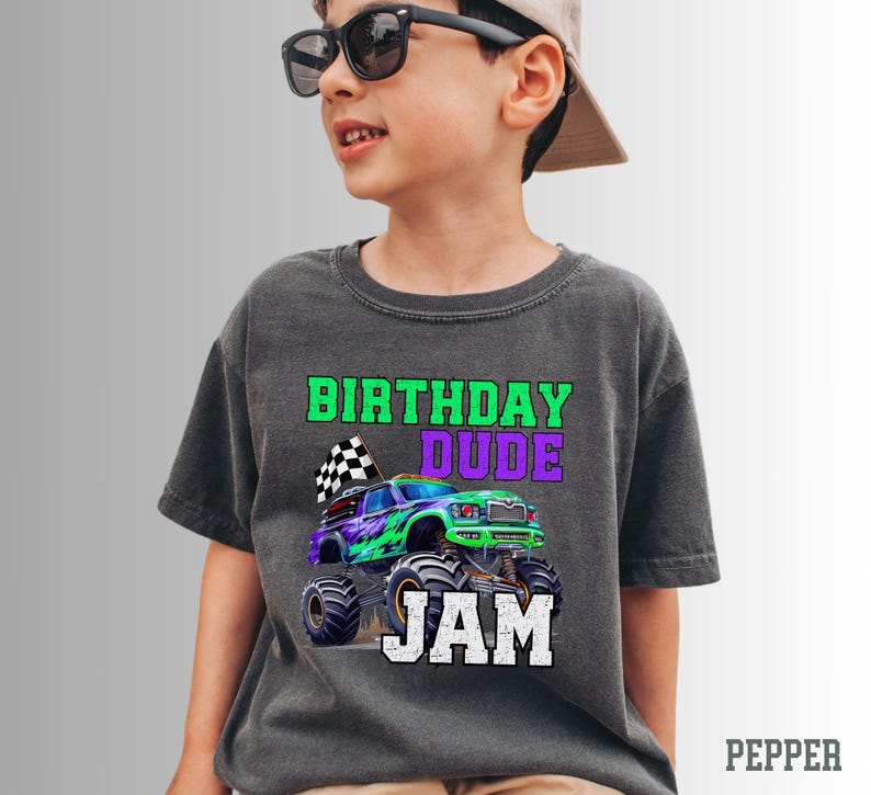 K&ouml;nnte beinhalten: Ein dunkelgraues T-Shirt mit einem gr&uuml;nen Monstertruck-Motiv und dem Text "Birthday Dude Jam".