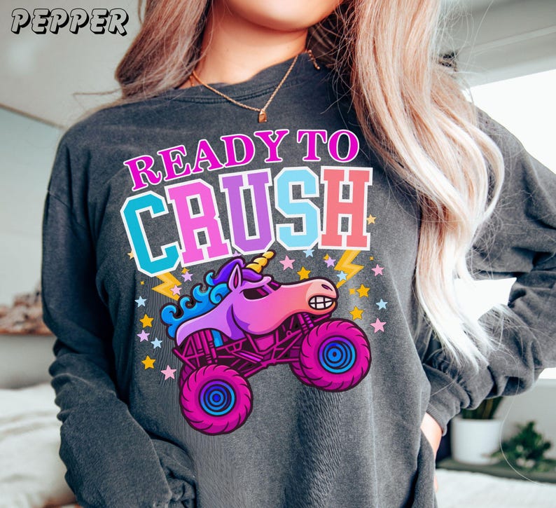 womens monster truck jam sparkle unicorn smash long sleeve comfort colors t-shirt in pepper Grey that says "Ready to Crush" in Multi-Colors Varsity Style Letters Patches with a Unicorn Monster Truck Cartoon Style animal truck  with stars and lightning. Perfect for Monster truck Jam Unicorn Truck Loving Girls, Teens, and Women