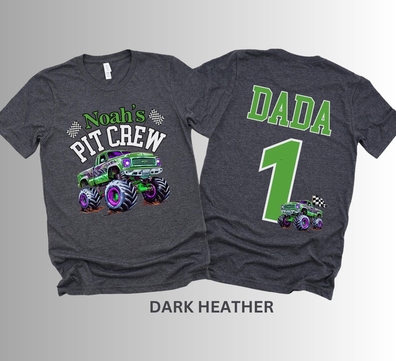 May include: Dark heather gray t-shirts with a monster truck graphic. One shirt says "Noah's Pit Crew" with a green and purple monster truck. The other shirt says "DADA 1" with a matching truck graphic.