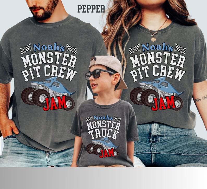 Puede incluir: Camisetas grises con tem&aacute;tica de monster truck. Las camisetas muestran el texto "Noah's MONSTER PIT CREW JAM" y "Noah's MONSTER TRUCK JAM" con un gr&aacute;fico de monster truck con tem&aacute;tica de tibur&oacute;n. Las camisetas son usadas por una familia.