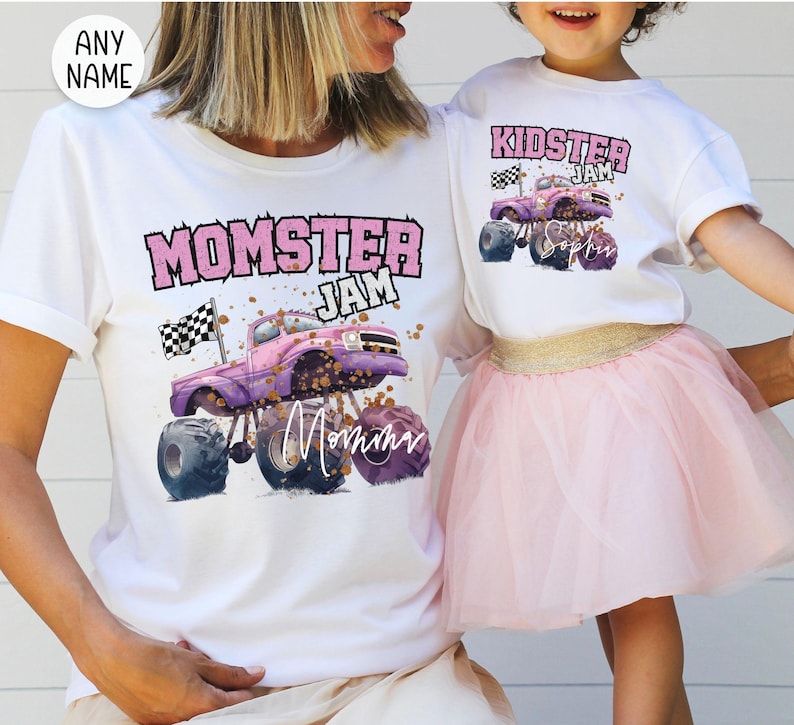 May include: White t-shirts with matching designs. One shirt says "Momster Jam" with a purple monster truck graphic and the word "Mommy". The other shirt says "Kidster Jam" with a similar truck graphic and the name "Sophia".